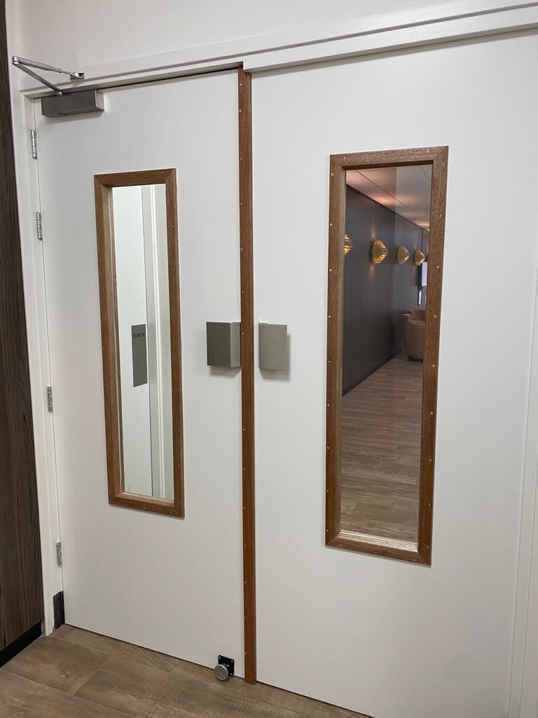 Brandwerende deur met glaspaneel in een hotel-situatie
