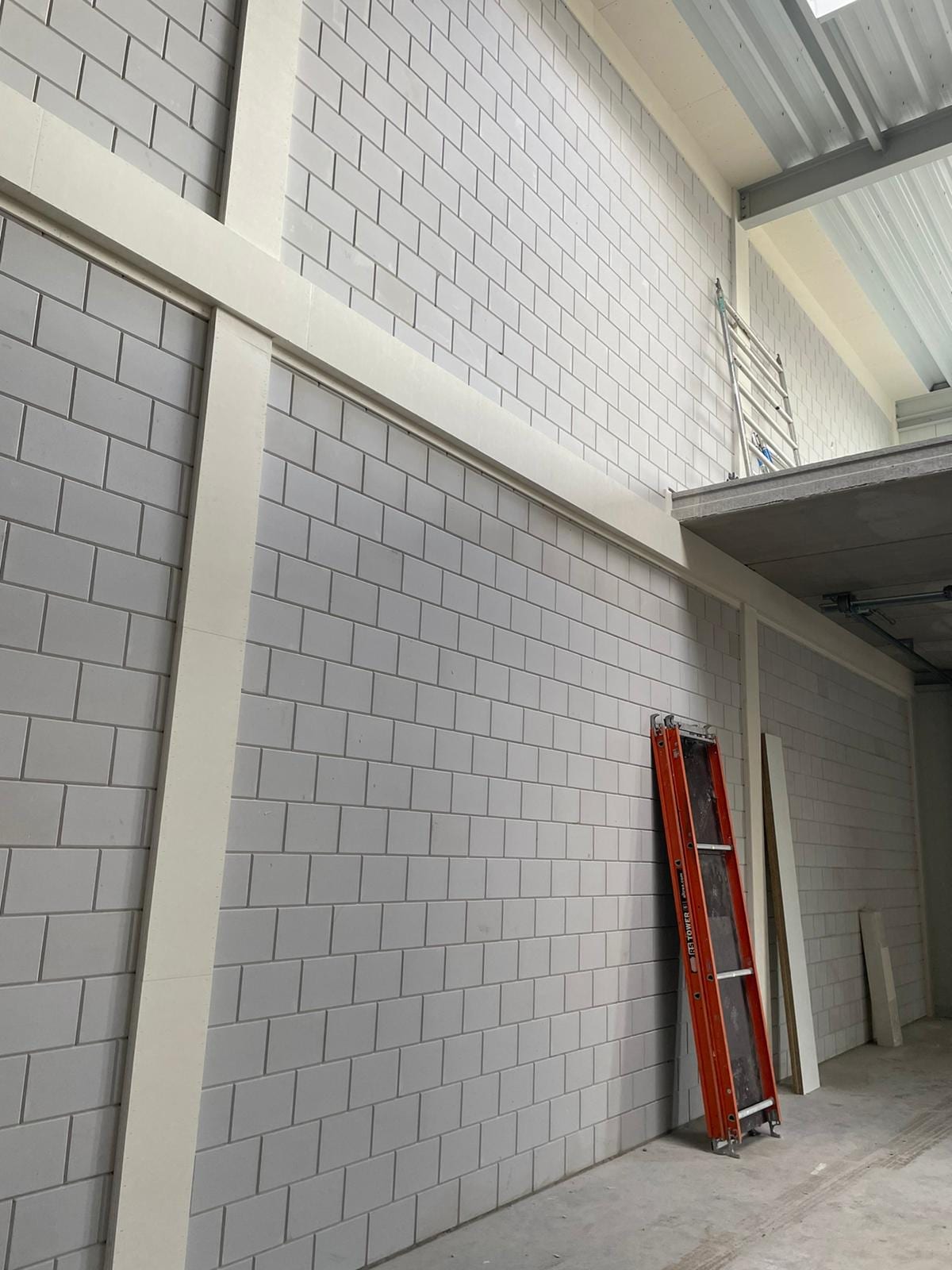 Stalen liggers met witte brandwerende coating in een bedrijfspand